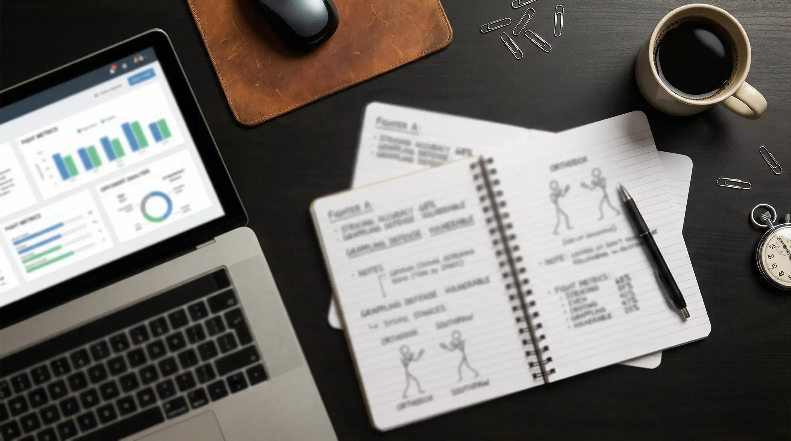 Notizbuch mit MMA-Kampfanalyse neben Laptop mit Statistiken